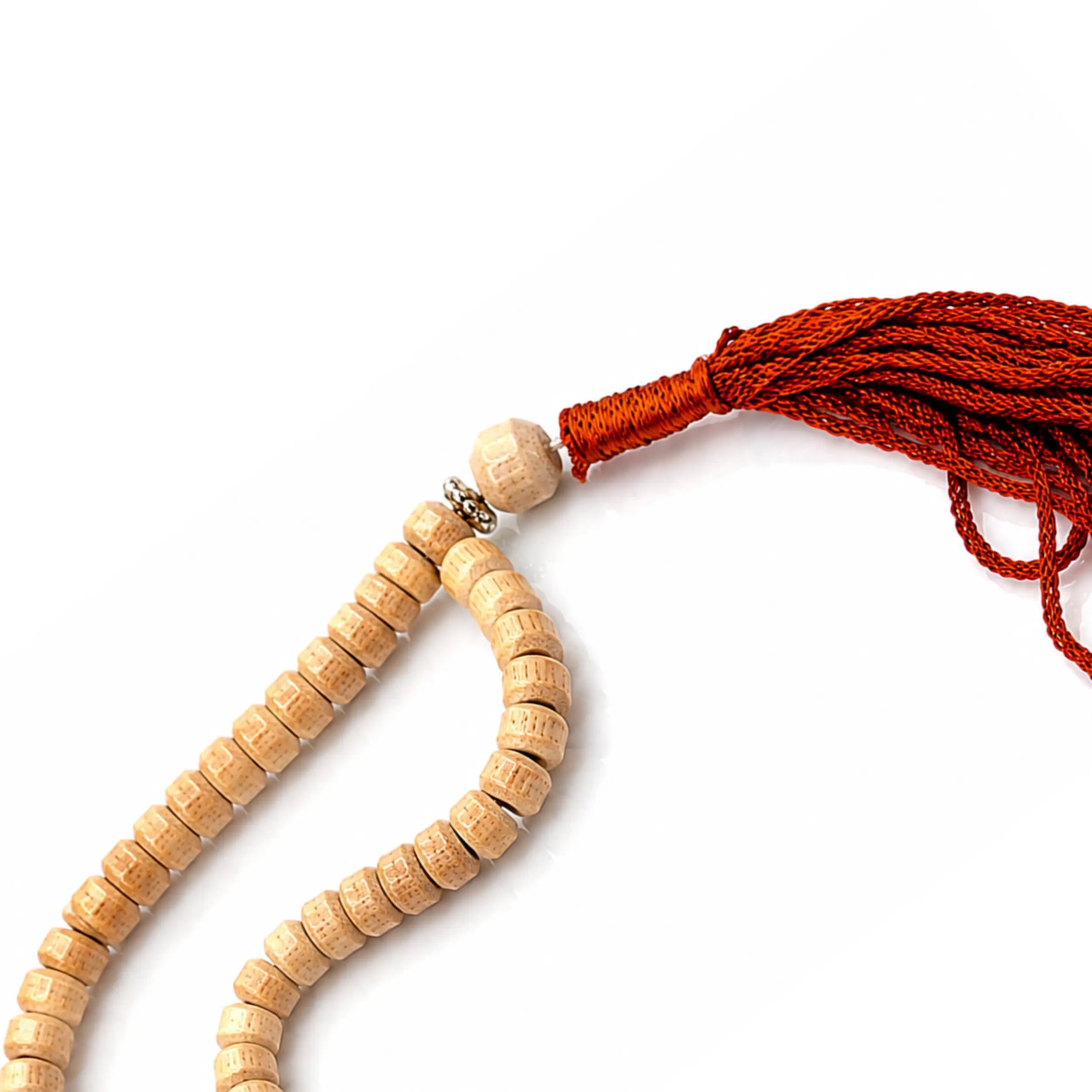Close-up of the wooden connector, silver spacer and brown tassel of a traditional euca