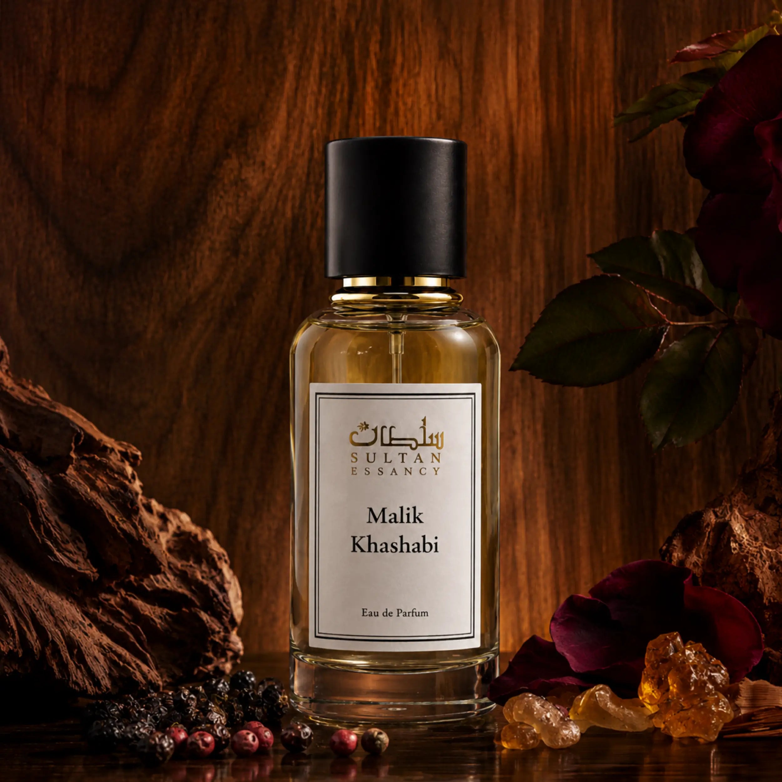 Malik Khashabi von Sultan Essancy Eau de Parfum im transparenten Glasflakon vor edlem Holz mit Pfeffer, Rose, Harz und warmen holzig-würzigen Duftakzenten